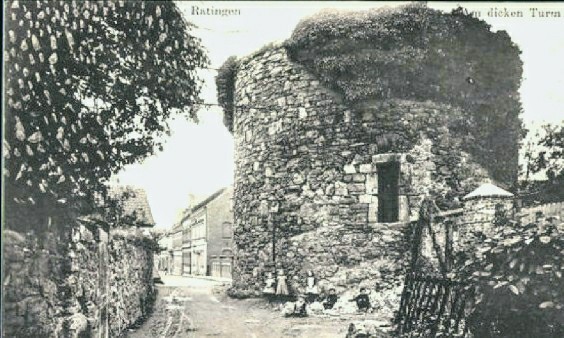 Eine historische Ansichtskarte aus Ratingen zeigt den alten, steinernen Turm mit Efeu bewachsen, umgeben von einer idyllischen, ländlichen Umgebung.